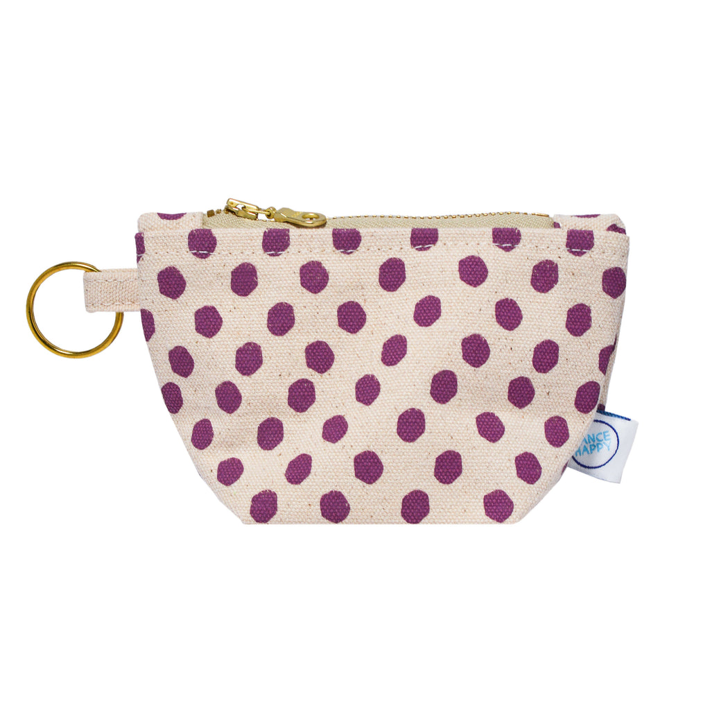 Small pouch with purple polka dots on a beige background